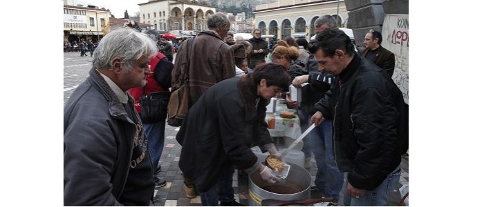 Волонтери на суповій кухні в Афінах розкладають їжу. Фото: Лефтеріс Пітаракіс